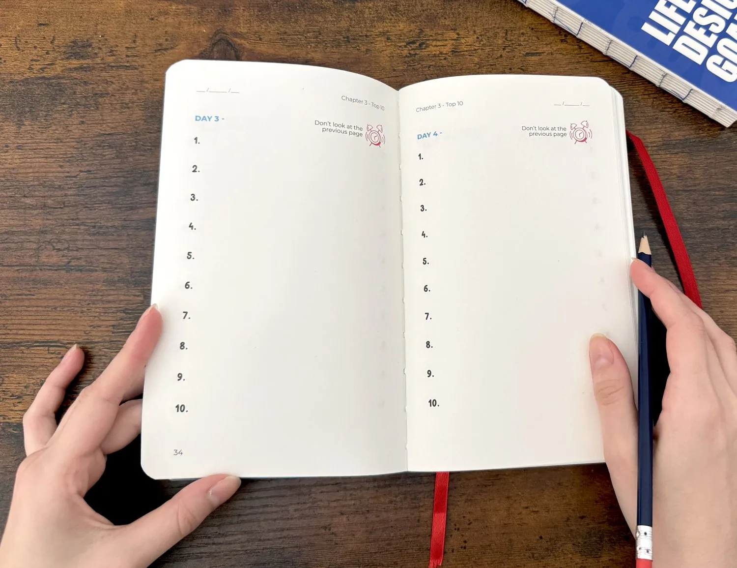 The Life Designer Goal planner, open with hands